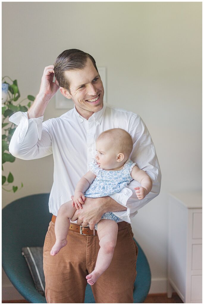 A portrait of a dad holding a 6 month old baby.