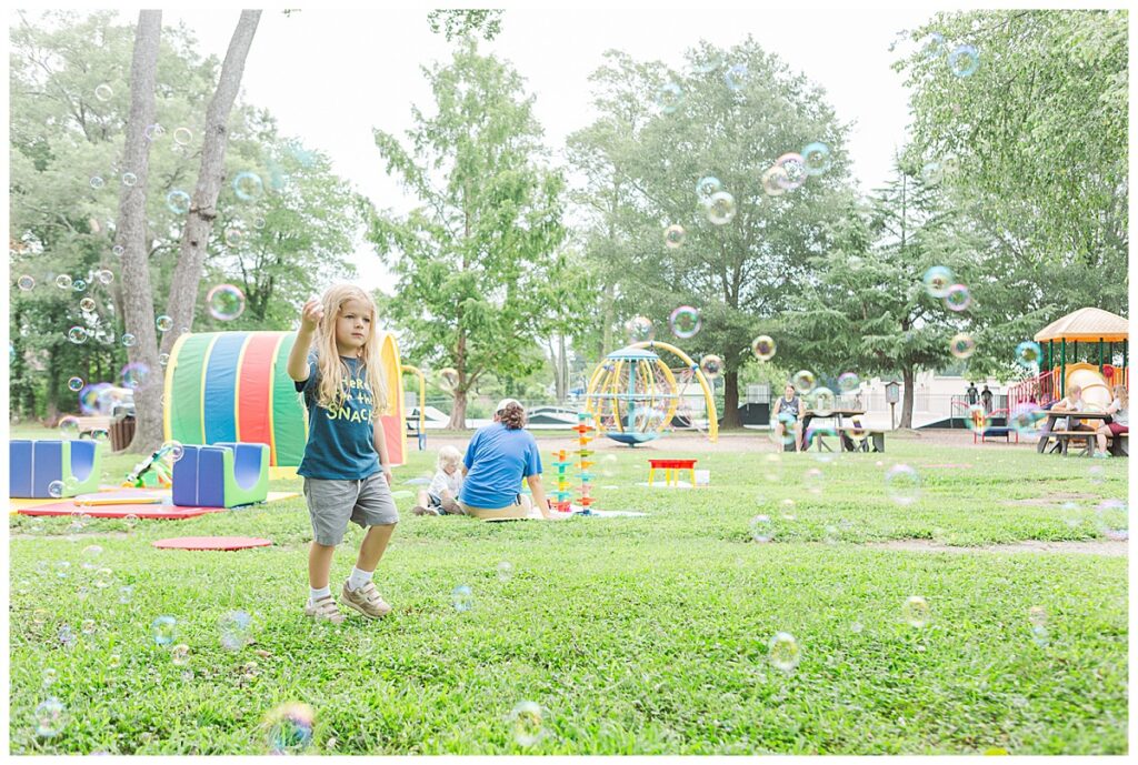 A child plays outside with bubbles at a free Hanover Parks and Recreation activity.